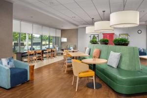 圆石城朗德罗克奥斯汀希尔顿欣庭套房酒店的一间设有绿色沙发和桌椅的等候室