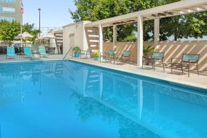 圆石城朗德罗克奥斯汀希尔顿欣庭套房酒店的一个带蓝色椅子和桌椅的游泳池