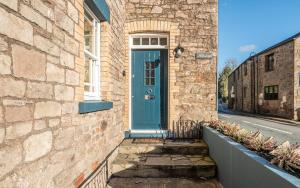 廷特恩Holmleigh cottage的街上有一扇蓝色门的砖房