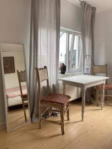 圣马尔滕斯·拉特姆Big apartments with mini-kitchen的一间带桌椅和镜子的用餐室