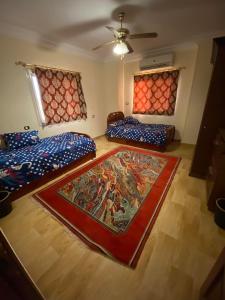 El-Qaṭṭaفيلا للايجار في كمبوند سمر قند的一间设有两张床的客房,地板上铺有地毯。
