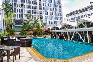 新加坡Peninsula Excelsior Singapore, A Wyndham Hotel的一座带桌子的大型游泳池和一座建筑
