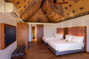 克罗托格奥瑞格斐济海滩度假酒店的一间卧室配有两张床和一台平面电视