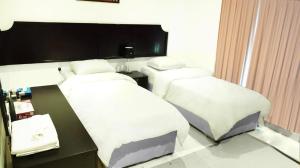 科威特Hotel Leaders Plaza Mahboula的酒店客房配有两张床和一张书桌