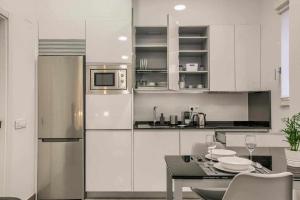马德里RiNa MADRID apartamento1的白色的厨房配有桌子和冰箱