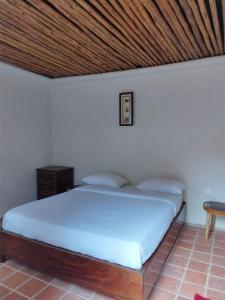恩德培Mia Safari Lodge and Restaurant的一间卧室设有一张木天花板床。
