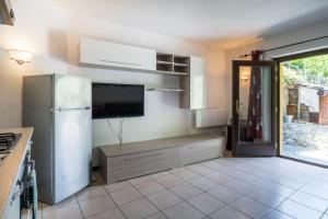 安泰伊-萨伊恩特-安德尔埃Residence Covalou的带冰箱的厨房和墙上的电视