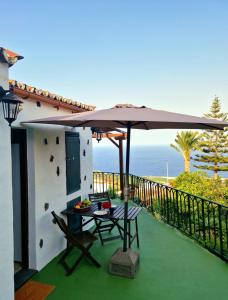 下布雷尼亚Casita Canaria con Vista的一个带桌子和遮阳伞的庭院