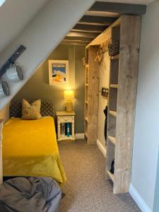 布里德波特The Bridge House的一间卧室设有黄色的床和书架