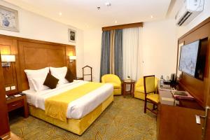 吉达Rose Jeddah Hotel的配有一张床和一台平面电视的酒店客房