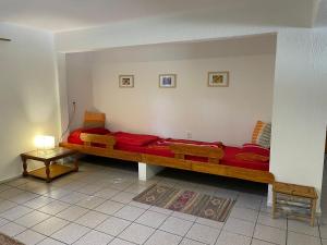 埃斯特角城Idyllische Ferienwohnung zwischen Meer und See的客厅配有长红色的沙发和桌子