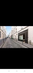 巴黎IMHOST - Amazing architect studio Père Lachaise的一条空的街道,有建筑和鹅卵石路