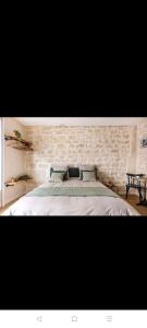 巴黎IMHOST - Amazing architect studio Père Lachaise的一间卧室设有一张带石墙的大床