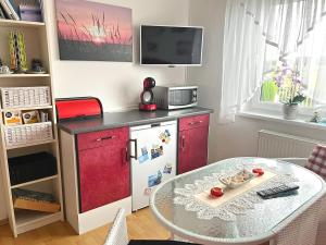 科尔平塞Ferienwohnung Loddin USE 2801的厨房配有红色冰箱和桌子