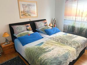 科尔平塞Ferienwohnung Loddin USE 2801的一间卧室配有一张带蓝色枕头的床。
