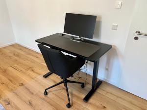 奥芬巴赫Workplace Apt/27inch Screen for 2 or 4/Kitchen的一张黑桌子,上面有一台电脑