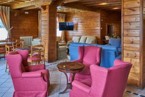 坎普罗东格列沃水疗酒店的一间带椅子和桌子的房间以及一台电视