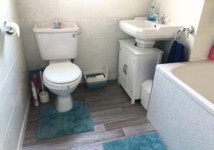 福尔柯克Scardroy Falkirk - 3 Bedroom Apartment的浴室配有卫生间、盥洗盆和浴缸。