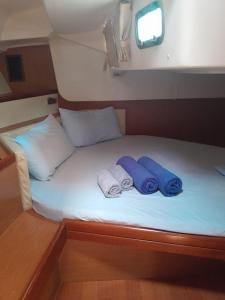 马尔扎梅米Private room on Sailing Yacht 'Victoire'的一张带两条毛巾和两个枕头的床