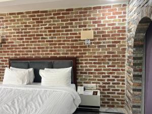 卡拉尔哥特Hotel Hayatt Sukkur的一间卧室设有砖墙和一张床