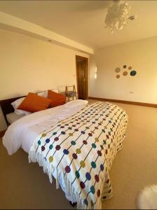基拉尼Evenly Balanced的一间卧室配有一张大床和色彩缤纷的被子