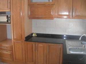 奥兰Bien situé T4 à Oran的厨房配有木制橱柜和黑色台面