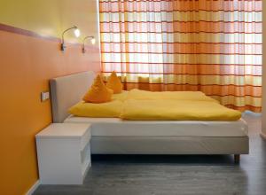 亚琛Hotel am Bahnhof的窗前的一张带黄色床单和枕头的床