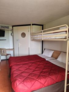 圣莫尔沙托鲁 - 圣莫尔普瑞米尔经典酒店的一间卧室配有两张双层床,铺有红色床单