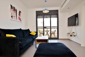 特拉维夫beautiful 2 bedrooms apartment with balcony的客厅配有黑色沙发和电视