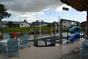 珊瑚角Heated pool, Family Fun, Tiki Bar, kayak, 3bd 2ba的一个带椅子和桌子的木制码头和一个码头