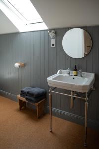 韦斯特波特The Roost的一间带水槽、镜子和凳子的浴室