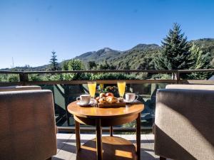 拉安戈斯图拉镇Resort de montaña - La Comarca的阳台上的桌子上摆放着食物和饮料