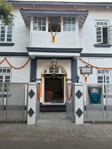 浦那Hotel Laxminarayan Niwas的白色的建筑,设有一扇门,门廊