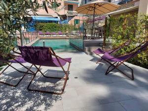 瓦拉泽苏里高酒店的游泳池旁的两把椅子和一把遮阳伞