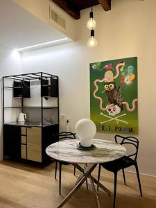 洛韦雷Dream Suite Lago D’iseo的配有桌椅和绘画的房间