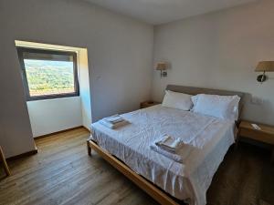 吉马良斯Quinta de Casal do Bairro Casa Grande的一间卧室配有一张床,上面有两条毛巾