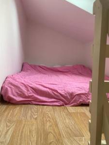 楠泰尔Maison de ville arborée avec cachet的铺有木地板的客房内的粉红色床铺