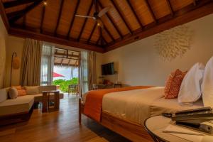 MachchafushiBarceló Whale Lagoon Maldives的一间卧室配有一张床、一张沙发和一张桌子