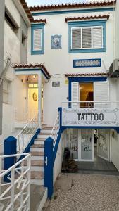 波尔蒂芒Hostel da Praia的蓝色和白色的建筑,前面有楼梯