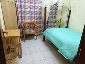 姆巴拉拉3-Bedroom Mbarara Apartment with Optional Farm Tour的配有床、椅子和桌子的房间