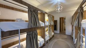 波尔蒂芒Hostel da Praia的客房设有三张双层床和吊灯。