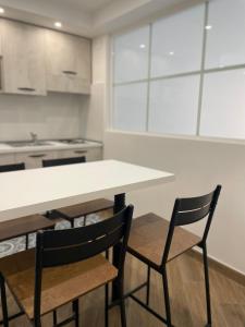 卡尔塔尼塞塔Maiolica Apartment的厨房配有白色的桌子和两把椅子
