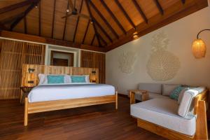 MachchafushiBarceló Whale Lagoon Maldives的一间卧室配有一张床和一张沙发