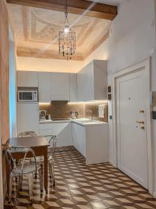 维罗纳Appartamento al Teatro Romano的厨房配有白色橱柜和桌椅