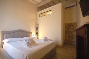 比博纳Residenza d'Epoca CAVALIERE的卧室配有白色床和毛巾