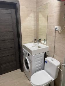 拉塞尼艾Apartamentai的一间带洗衣机和水槽的浴室