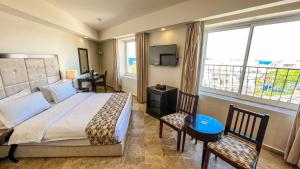 亚喀巴亚福克酒店的一间卧室设有一张床和一个大窗户