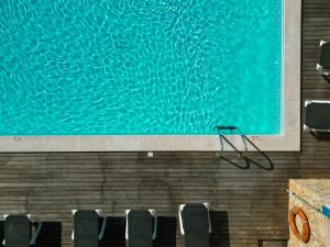 拉戈斯卡尔维海滩酒店 的一座带椅子的游泳池,旁边是一幅大画