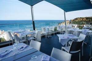 拉戈斯卡尔维海滩酒店 的一间设有白色桌椅的海洋餐厅