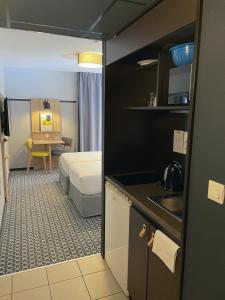 里昂里昂市奥德利生物园公寓式酒店的带卧室、床和厨房的客房